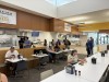 Students sit at tables and choose food options at buffets in the commons at lunchtime
